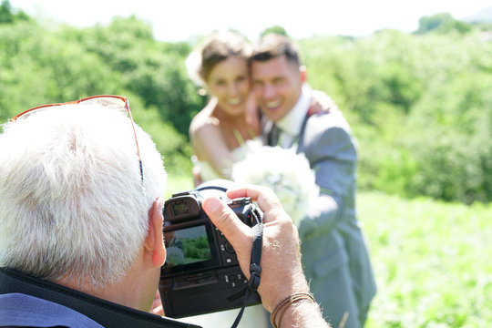 Photographer taking wedding pictures of bride and groom