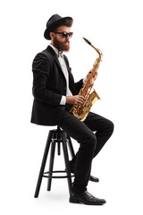 Obraz na płótnie Canvas Jazz musician with a saxophone sitting on a chair