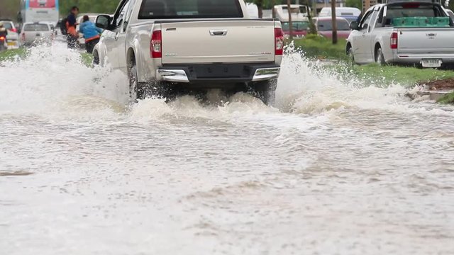 LOEI, THAILAND - MAY 18 2017: Car traffic on a flooded city road, Thailand Storm Flooding Bloor flooded from the heavy rain at LOEI Province, THAILAND on MAY 18 2017.