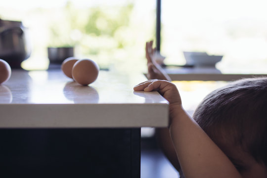 petite main sur la table de la cuisine avec oeufs