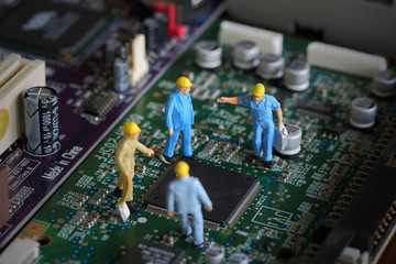 Selective focus of miniature engineer meeting, worker fixed problem and repair chip mainboard...