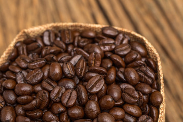Sack of coffee beans on wood background