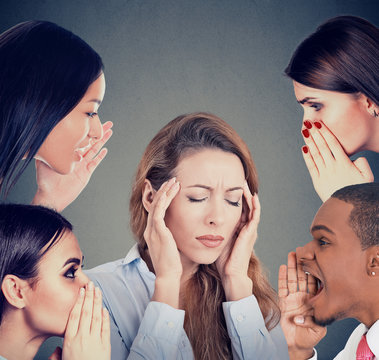 Group of people whispering gossip to a stressed woman suffering from headache
