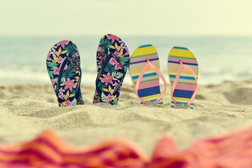 two pair of flip-flops on the beach