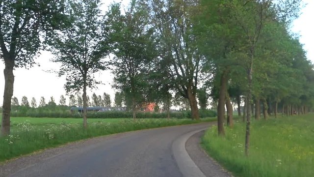 Cycling on a winding country road during a beautiful evening in spring.