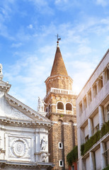 red tower  and a cathedral on the narrow street. Venice, Italy..