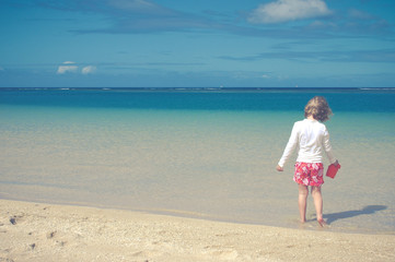 Fototapeta na wymiar Child Plays On Tranquil Tropical Beach