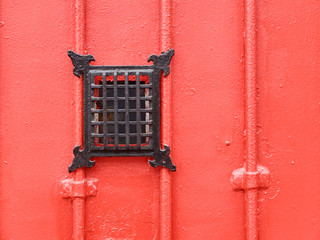 Red metallic door with peep hole. A good way to select the visitors.