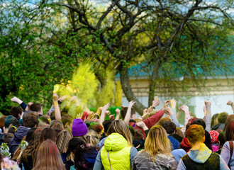 Holiday holi, young people in smoke dancing hands up outdoors