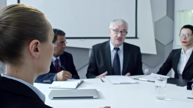 Woman answering questions of HR managers while having job interview in the office