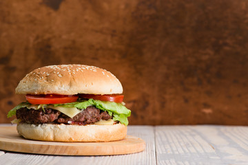 Tasty burger on a wooden background copyspace