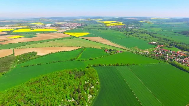 Camera flight over blooming rapeseed field. Renewable energy source. Farmers use drones to inspect of cultivated fields. Production of biofuel in Czech Republic, European Union. 