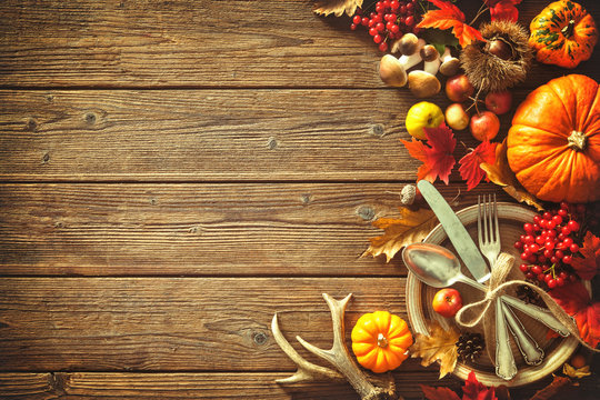 Autumn background from fallen leaves and fruits with vintage place setting
