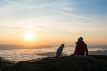 Girl and her dog relaxing on a peak