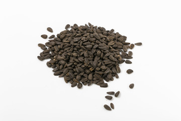 Black fried sunflower seeds on a white background.