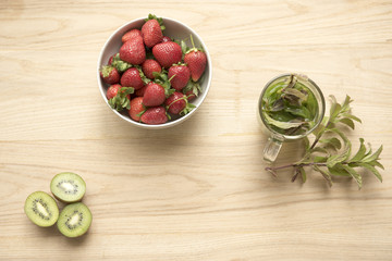 Strawberries with mint tea and kiwi fruit on a wooden background 