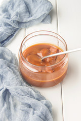 Salted caramel in a jar, dessert spoon, selective focus, vertical

