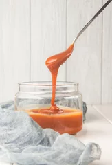 Foto op Plexiglas Salted caramel in a jar, dessert spoon, selective focus, vertical   © giftulya