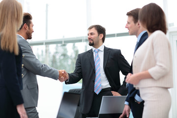 Fototapeta premium Two business people shaking hands at the business meeting with t