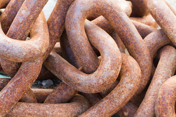 Fototapeta premium A full frame image of thick, heavy industrial chains that are rusty, weather and worn an industry background image.