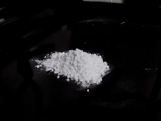 Cocaine drug powder pile on black background