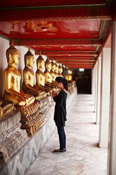 Woman praying in front of monument