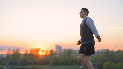 Boxer with skipping rope outdoors,sunset