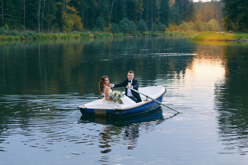 Fototapeta na wymiar The bride and groom in a rowboat on the lake