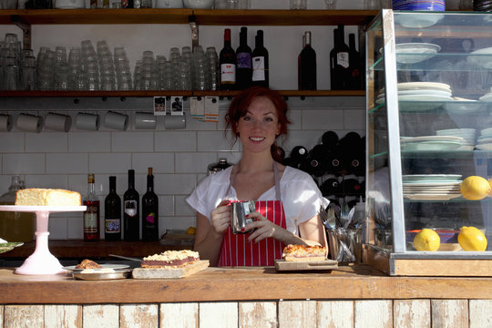 Woman in apron working at cafe