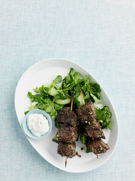 Plate of beef kebabs with salad