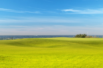 Fototapeta premium Green golf field on the sunny coast of Mediterranean sea