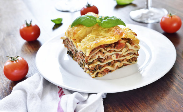 Fresh italian meat lasagne with cherry tomatoes. Italian pasta dish on a white plate.