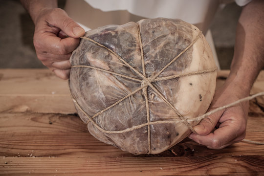 Butcher tying meat in shop