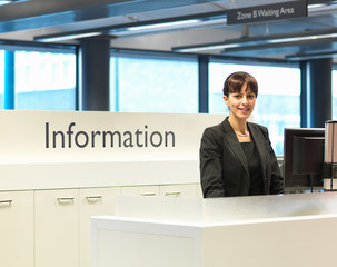 Receptionist smiling at information desk