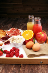 breakfast on table with bread rolls, croissants, coffe and juice