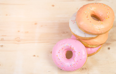 Colorful donuts on wooden table
