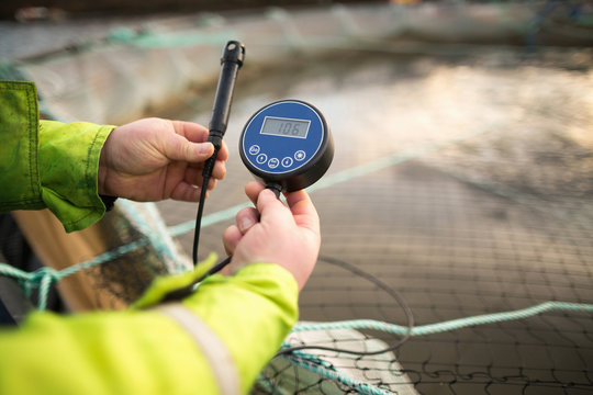 Worker on salmon farm in rural lake