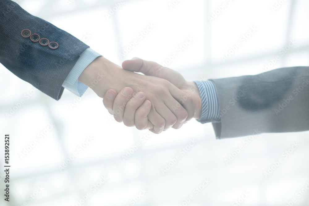 Wall mural businessman shaking hands to seal a deal with his partner