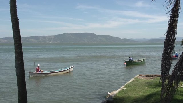 fisherman in boat in lake, Laguna,  Santa Catarina