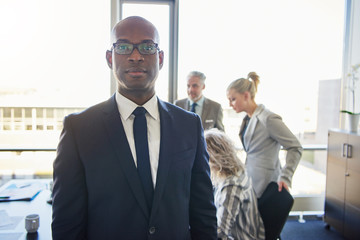 Black businessman standing in front of team