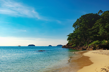 Beautiful seascape with sea, bright blue sky and rocks with tropical trees at Lonely Beach, Koh Chang,Thailand. Beautiful ocean or sea on sunny day. Nature vacation background.