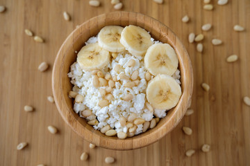 Healthy eating. Cottage cheese with banana and pine nuts.