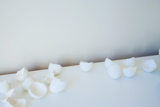 Broken eggshells on white table