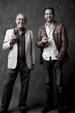 Grown-up father and son having a beer