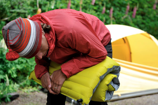 Woman deflates her sleeping pad at camp, Refugio Los Troncos, El Chalten, Argentina
