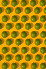 Lime pattern on yellow background. Minimal flat lay concept.