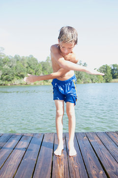 Boy swinging arms by jetty