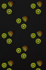 Pattern of kiwi. Top view of the sliced kiwi on black background. Minimal flat lay concept.
