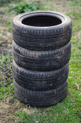 Car tyres on the ground. Stack of used tyres sale in countryside.