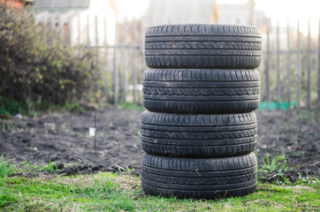 Car tyres on the ground. Stack of used tyres sale in countryside.